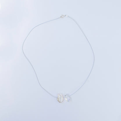 Delicate crystal quartz and baroque pearl necklace on light blue cord with sterling silver clasp.